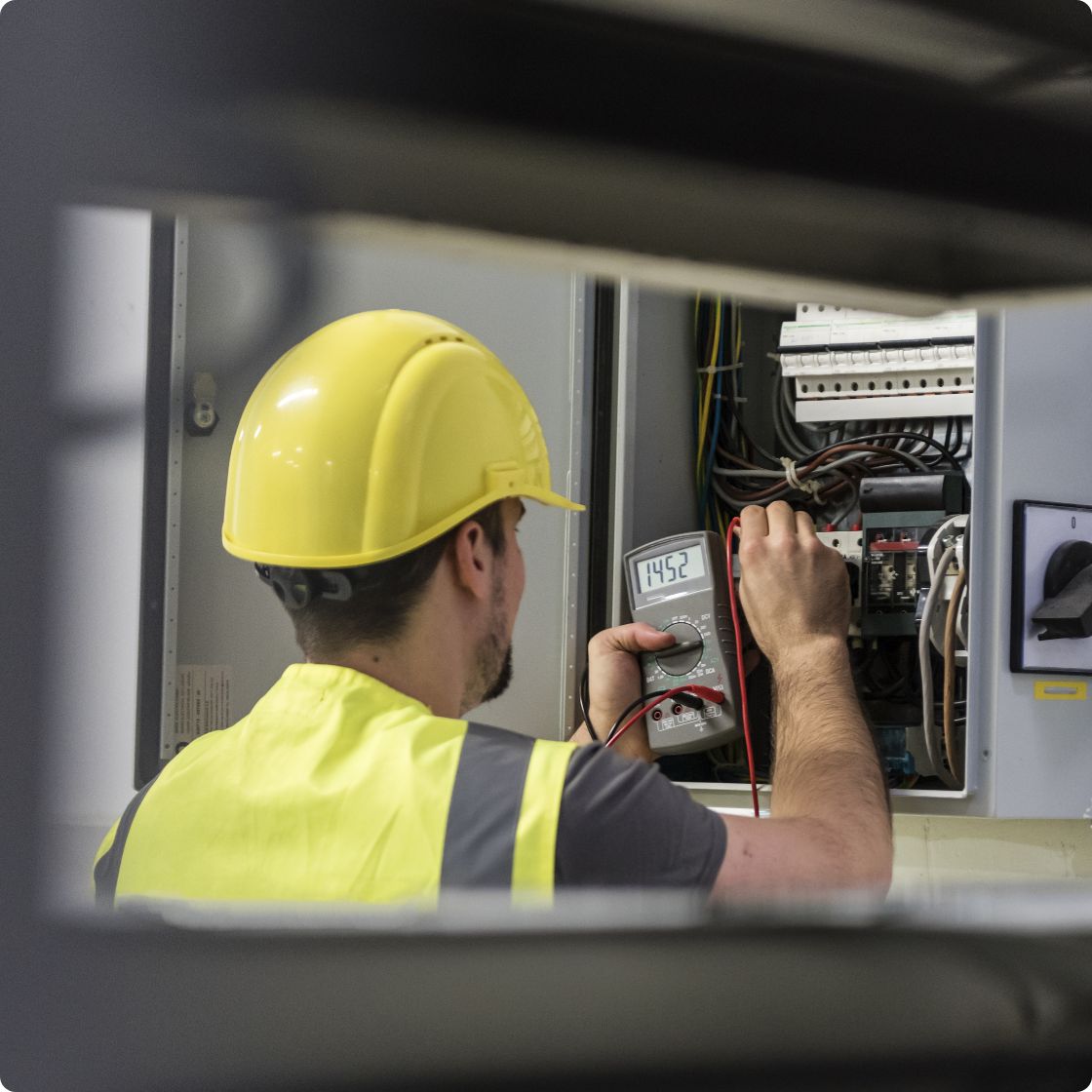 Man testing electric dashboard with multimeter