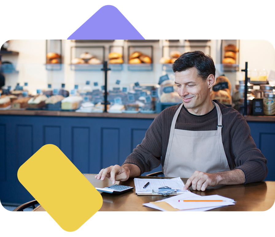 Naeratav mees arvutab kalkulaatoriga.